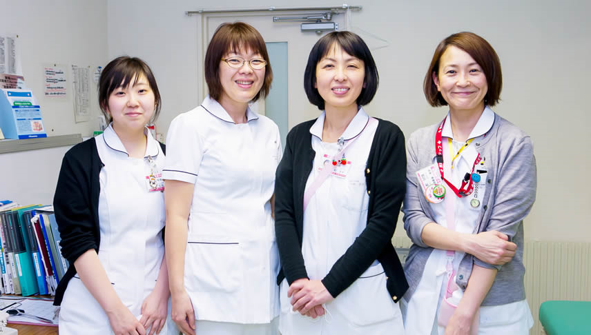 笑顔を向ける4人の看護師達の写真